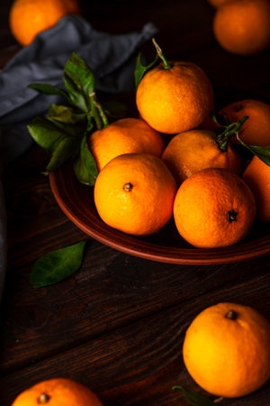 Tangerines in a plate on a wooden tableの写真素材