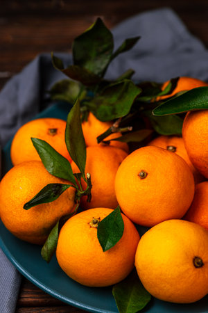 Tangerines in a plate on a wooden tableの写真素材