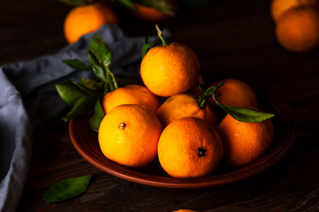Tangerines in a plate on a wooden tableの写真素材