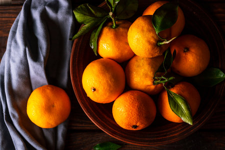 Tangerines in a plate on a wooden tableの写真素材