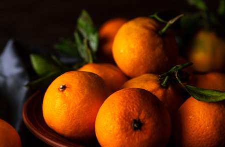 Tangerines in a plate on a wooden tableの写真素材