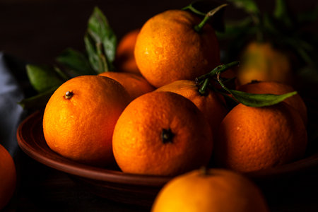 Tangerines in a plate on a wooden tableの写真素材