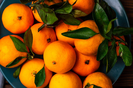 Tangerines in a plate on a wooden tableの写真素材