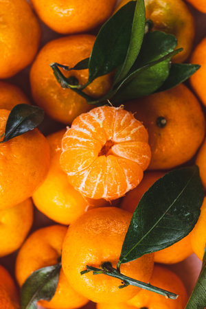 Tangerines with leaves and peeled tangerineの写真素材