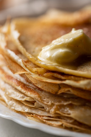 A stack of pancakes with a piece of melted butterの写真素材