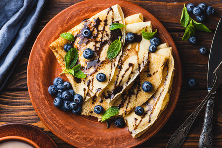 Pancakes with blueberries, chocolate sauce and mintの写真素材