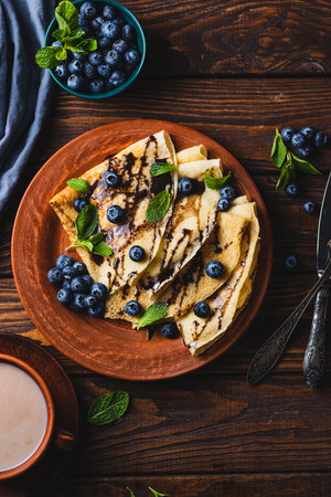 Pancakes with blueberries, chocolate sauce and mintの写真素材