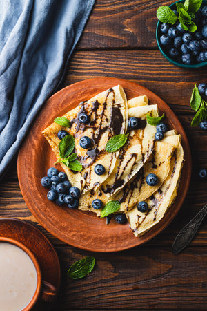 Pancakes with blueberries, chocolate sauce and mintの写真素材