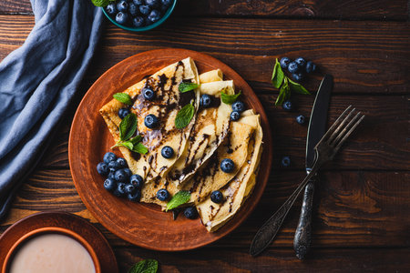 Pancakes with blueberries, chocolate sauce and mintの写真素材