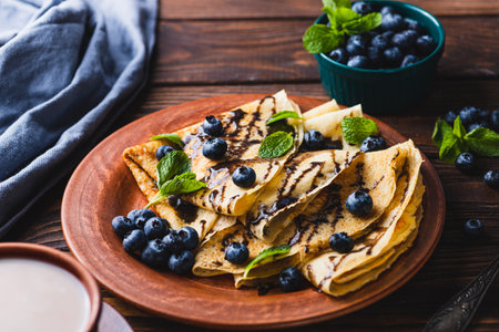 Pancakes with blueberries, chocolate sauce and mintの写真素材