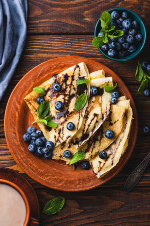 Pancakes with blueberries, chocolate sauce and mintの写真素材