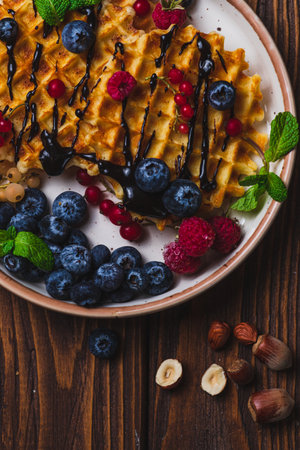 Waffles with berries and chocolate sauceの写真素材
