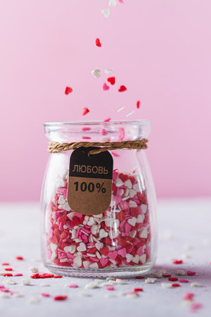 A glass jar with small heartsの写真素材