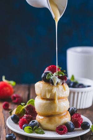 Cheesecakes served with berries and condensed milkの写真素材