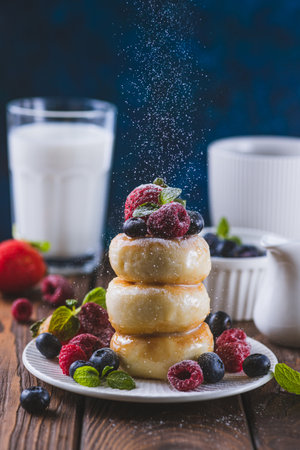 Cheesecakes served with berries and condensed milkの写真素材