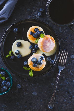 Cheesecakes served with berries and condensed milkの写真素材