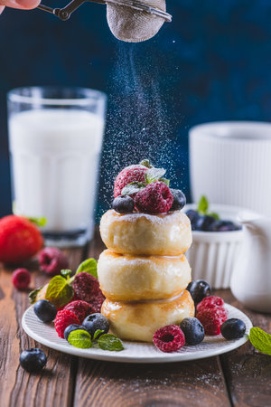Cheesecakes served with berries and condensed milkの写真素材