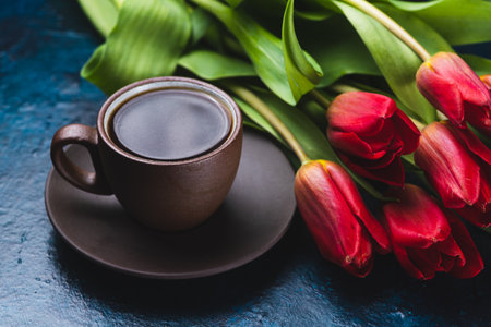 a cup of coffee and a bouquet of tulipsの写真素材