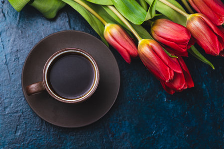 a cup of coffee and a bouquet of tulipsの写真素材