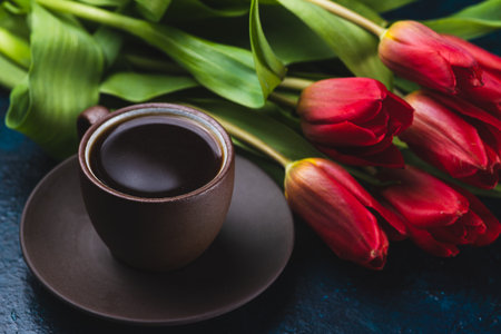 a cup of coffee and a bouquet of tulipsの写真素材