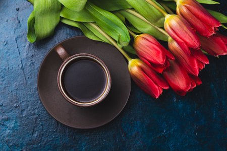 a cup of coffee and a bouquet of tulipsの写真素材