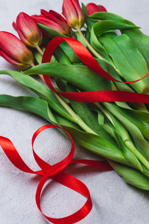 A bouquet of tulips tied with a red ribbon in the form of the number eightの写真素材