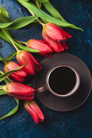 a cup of coffee and a bouquet of tulipsの写真素材