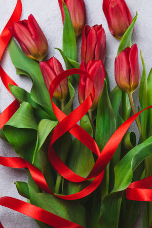 A bouquet of tulips tied with a red ribbon in the form of the number eightの写真素材