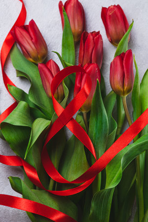 A bouquet of tulips tied with a red ribbon in the form of the number eightの写真素材