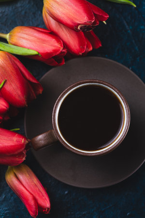 a cup of coffee and a bouquet of tulipsの写真素材