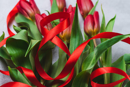 A bouquet of tulips tied with a red ribbon in the form of the number eightの写真素材