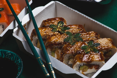 Sushi in delivery boxes on the table and chopsticksの写真素材
