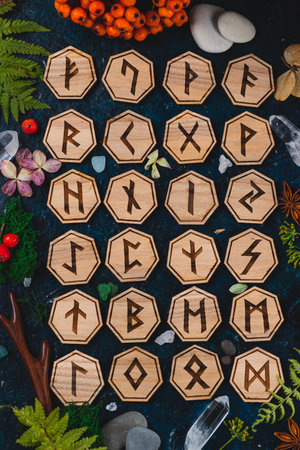Wooden runes are lying on the table among various objects. Astrology and esotericism. Senior Futharの写真素材