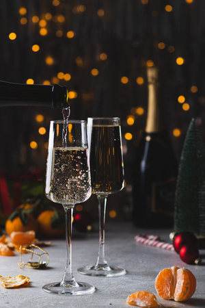 Champagne is poured into a glass from a bottleの写真素材