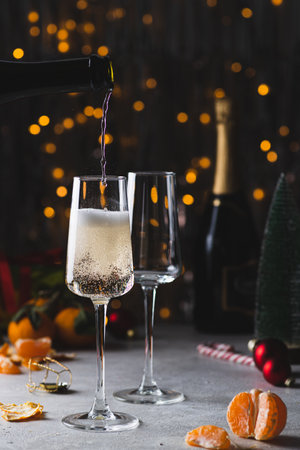 Champagne is poured into a glass from a bottleの写真素材