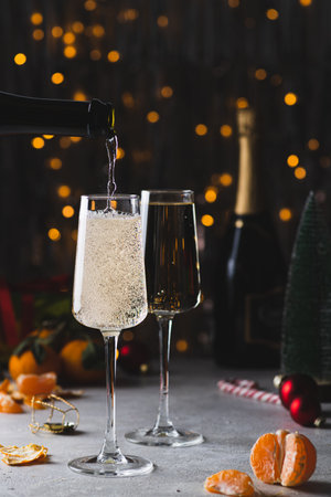Champagne is poured into a glass from a bottleの写真素材
