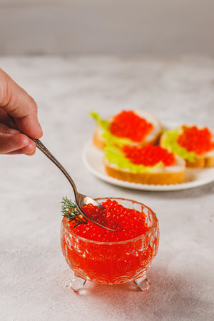 Red caviar in a caviar dish with a sprig of dillの写真素材