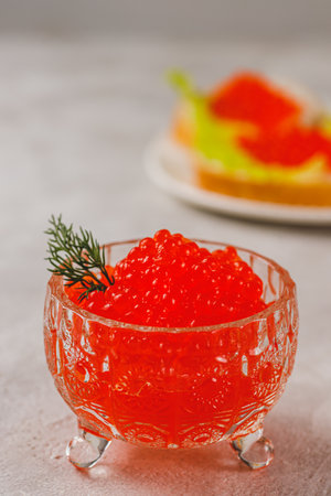 Red caviar in a caviar dish with a sprig of dillの写真素材