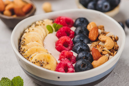 Smoothie bowl with raspberries and blueberries and nutsの写真素材