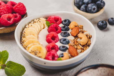 Smoothie bowl with raspberries and blueberries and nutsの写真素材