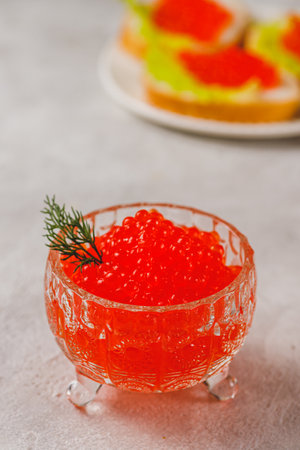 Red caviar in a caviar dish with a sprig of dillの写真素材
