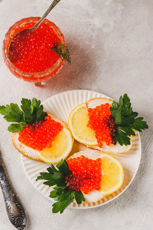 Sandwiches with red caviar, a slice of lemon, and a sprig of parsleyの写真素材