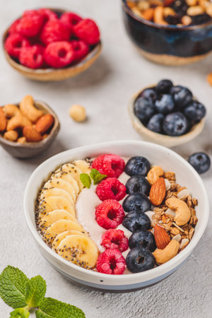 Smoothie bowl with raspberries and blueberries and nutsの写真素材