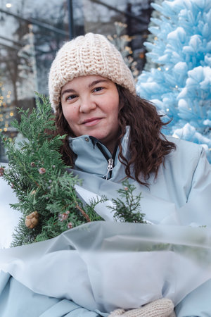 Portrait of a young woman with Christmas tree in the city.の写真素材