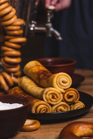 Rolled pancakes on a plate next to dryers and a samovarの写真素材