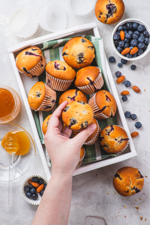 Blueberry muffins in a wooden tray in the kitchenの写真素材