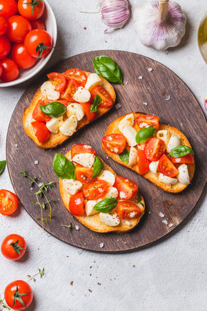 Bruschetta caprese with cherry tomatoes and mozzarella garnished with basil