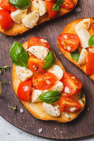 Bruschetta caprese with cherry tomatoes and mozzarella garnished with basilの写真素材