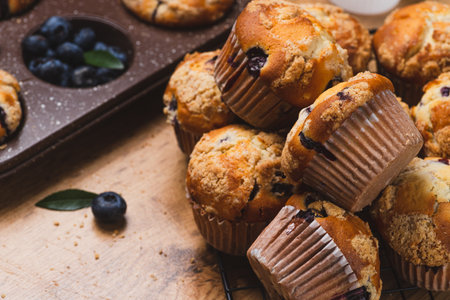 Blueberry muffins on a rustic table in a moldの写真素材