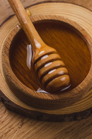 A jar of honey and a spoon, honey is pouringの写真素材